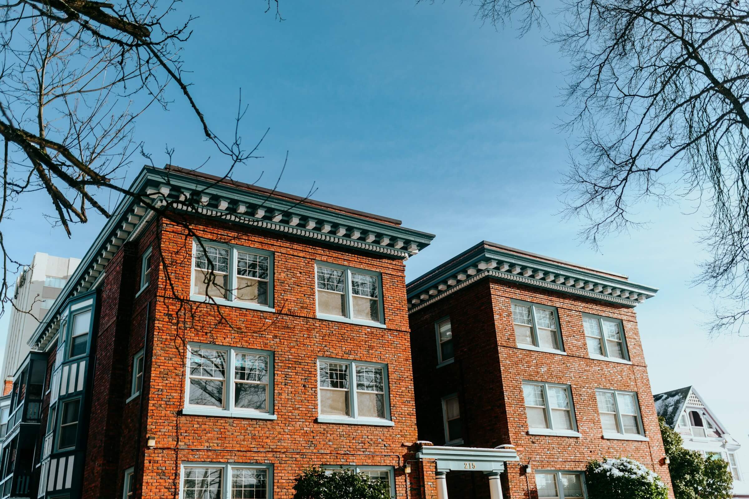 Low-rise brick apartment buildings against a blue sky